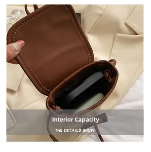 Macro view of woven straw crossbody bag interior showing phone and accessory storage