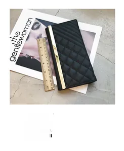 Detail of long black quilted wallet for women with gold metal bar and size scale