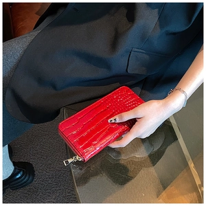 Macro shot of red crocodile texture long clutch wallet with a gold zipper closure