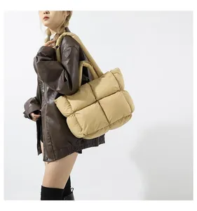 Close-up of khaki quilted puffer tote bag featuring oversized square padding and soft straps