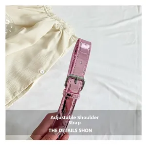 Detail of pink glossy PU leather adjustable shoulder strap with silver buckle hardware