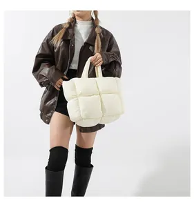 Macro shot of off-white quilted tote bag showing detailed puff stitch and soft glossy texture