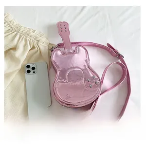 Macro detail of a pink violin-shaped crossbody bag with silver rivet studs and smooth finish