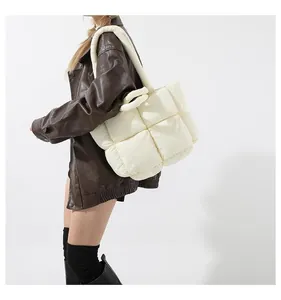 Detailed view of off-white quilted puffer tote bag with stitched square pattern