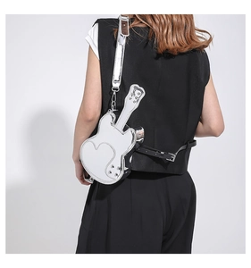 Detail of silver guitar-shaped crossbody bag with heart stitching and adjustable strap