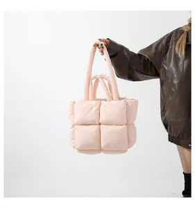 Detailed view of pink quilted puffer tote bag with dual handles and padded texture