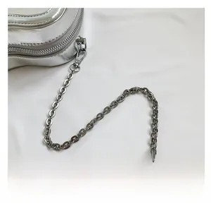 Close-up of metallic silver mini bag with sleek chain strap and textured finish
