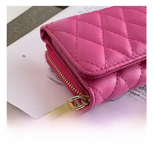 Macro shot of rose pink quilted leather wallet with high-quality gold hardware zipper