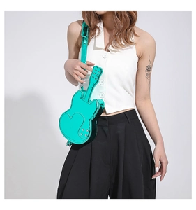 Detail of mint green violin-shaped crossbody bag with heart stitching and metal studs