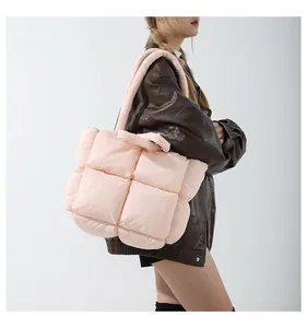 Detail of pink quilted puffer tote bag showing soft square texture and shoulder strap