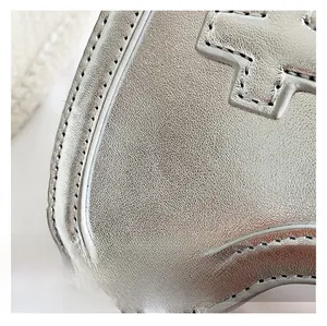 Macro detail of silver metallic textured fabric with fine stitching and relief design