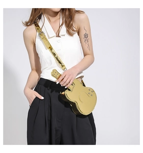Detailed macro view of the gold mirror finish on a violin shaped crossbody fashion bag