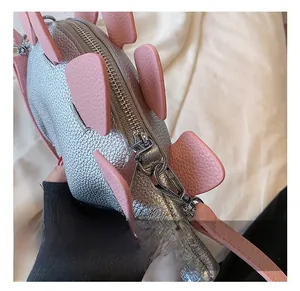 Close-up of durable silver hardware and metal chain strap on dinosaur shoulder bag
