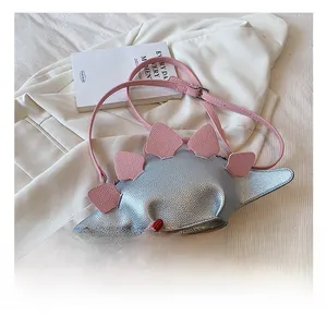 Detail showing the dinosaur shape crossbody bag with silver pebbled leather and pink accents
