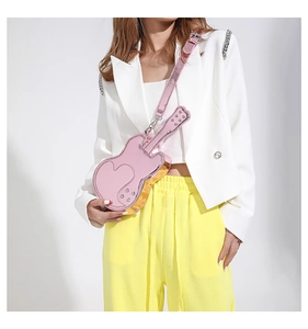 Detail of creative violin-shaped crossbody bag in pink with metallic gold accents