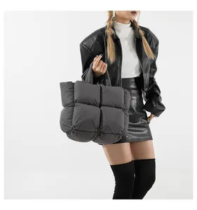 Close-up of a large grey quilted puffer tote bag with puffy grid stitching detail