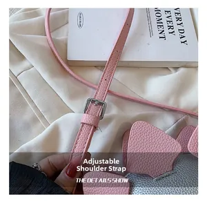 Detail of adjustable silver buckle on pink textured leather dinosaur crossbody bag strap