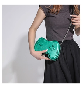 Detail of creative green game controller crossbody bag with metallic finish and chain strap
