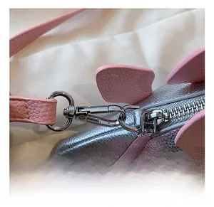 Close-up of durable silver metal lobster clasp and pink lychee leather shoulder strap detail