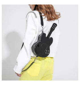 Detail view of a black glossy violin shaped crossbody bag with heart stitching and rivets