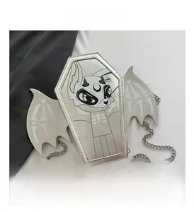 Detail of silver coffin-shaped crossbody bag with bat wings and metal chain strap