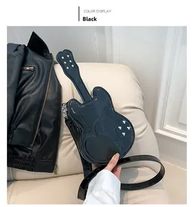 Detail of guitar-shaped black patent leather bag with silver rivets on a sofa