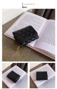 Detail view of black quilted accordion card wallet with golden zipper and luxury embroidery