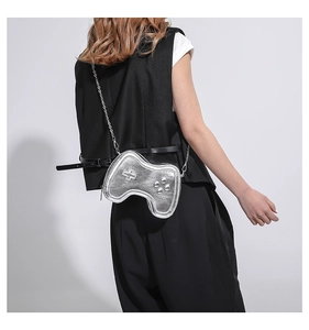 Detailed back view of a silver gamepad shaped mini crossbody bag on a black outfit