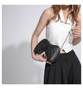 Detail of creative game controller shaped crossbody bag with silver chain strap and PU leather