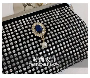 Dettaglio della borsa da sera nera con strass argentati e ornamento di gemma blu