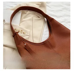 Dettaglio borsa Hobo in pelle martellata marrone con tracolla larga e cuciture