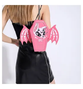 Detailed back view of pink coffin bag with bat wings and chain strap on a model
