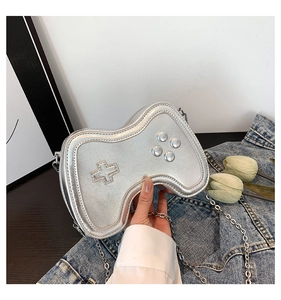 Detail of silver game controller shaped crossbody bag with metallic chain strap