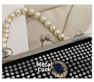 Dettaglio borsa da sera con strass neri, manico di perle e chiusura in metallo a scatto