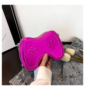 Macro view of game controller shape crossbody bag with embossed buttons and metallic pink finish