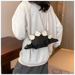 Detail of creative stegosaurus dinosaur crossbody bag with white spikes and black leather