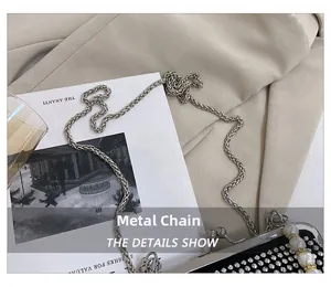 Dettaglio borsa da sera con decoro di perle, strass di cristallo e catena in argento