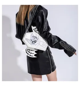 Detail of white coffin-shaped crossbody bag with bat wings and gothic cartoon print