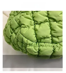 Macro detail of grass green quilted nylon fabric with plush square stitching pattern
