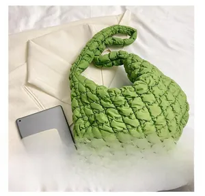 Size comparison of green quilted tote bag next to a tablet and a mobile phone