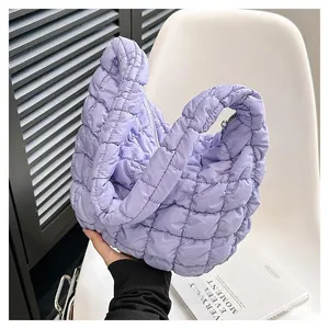 Detailansicht der hellvioletten gesteppten Cloud-Tasche mit Karomuster auf einem Stuhl