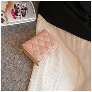 Macro detail of pink quilted PU leather wallet with elegant gold zipper and stitching