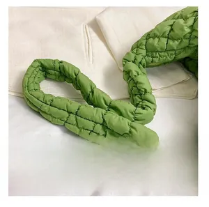 Close-up of green quilted shoulder strap detail on a padded cloud puffer tote bag
