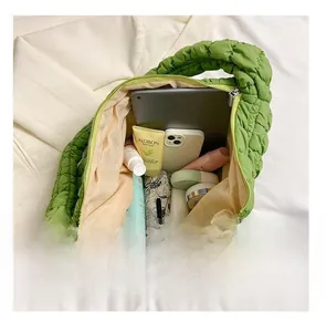 Quilted green puffy tote bag showing spacious interior with tablet, umbrella and makeup