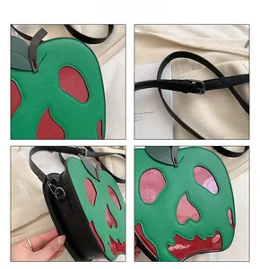 Detail view of green and red poison apple shoulder bag with skull cutout and silver hardware