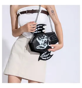 Detail of coffin-shaped black leather crossbody bag with bat wings and chain strap