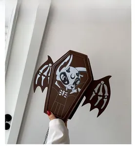 Detail of coffin-shaped brown crossbody bag with bat wings and skull graphic