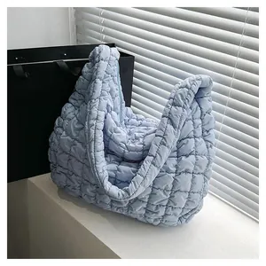 Detail of light blue quilted cloud bag showing soft puff texture and nylon fabric finish