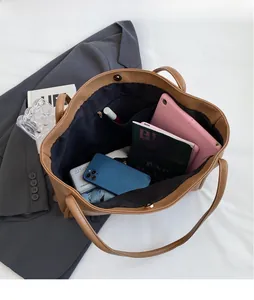 Internal view of large brown leather tote bag showing ample storage space and zip pocket