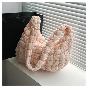 Detail of light pink puff cloud bag showing soft quilted texture and padded handle